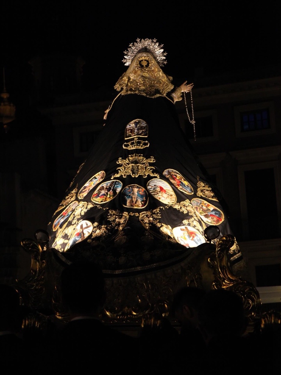 María Santísima de la Súplica en su paso procesional nocturno con manto negro y medallones iluminados